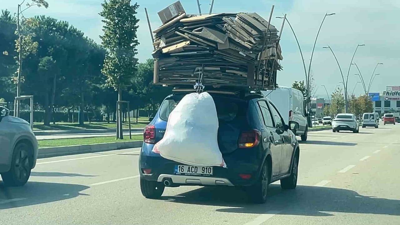 Bursa'da otomobilin üzerine yüklenen kartonlar trafikte tehlike yarattı